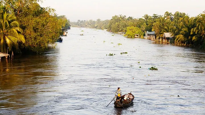 Cuộc sống sông nước bình dị diễn ra gần Cầu Tràu Hội, xã Nhơn Nghĩa, Phong Điền, Cần Thơ với kênh rạch và cây xanh.